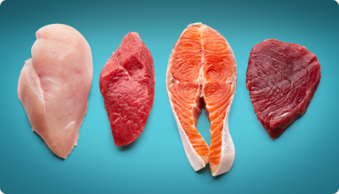 A selection of raw fillets of meat and fish, including chicken and salmon. 