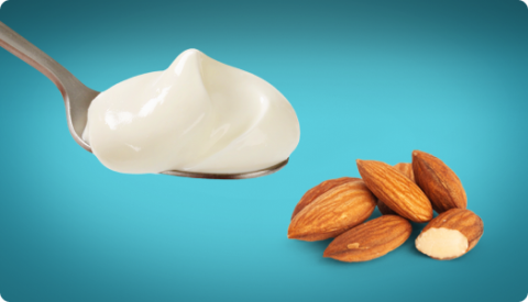 A spoonful of yogurt next to some nuts.