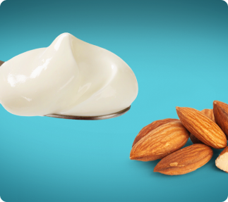 A spoonful of yogurt next to some nuts.